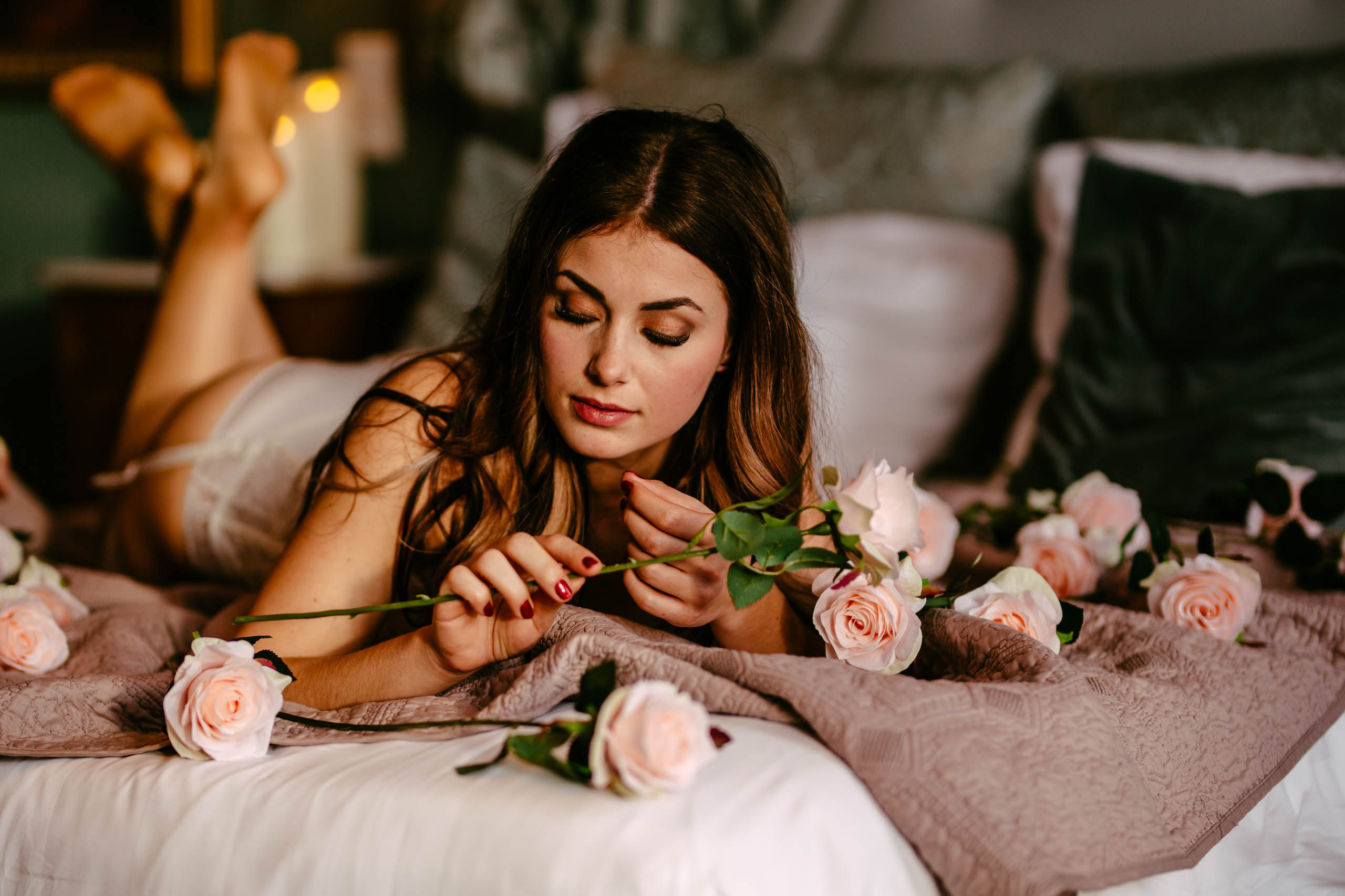 Een sensuele boudoirshoot van een vrouw in Delft, omringd door prachtige rozen op een bed.