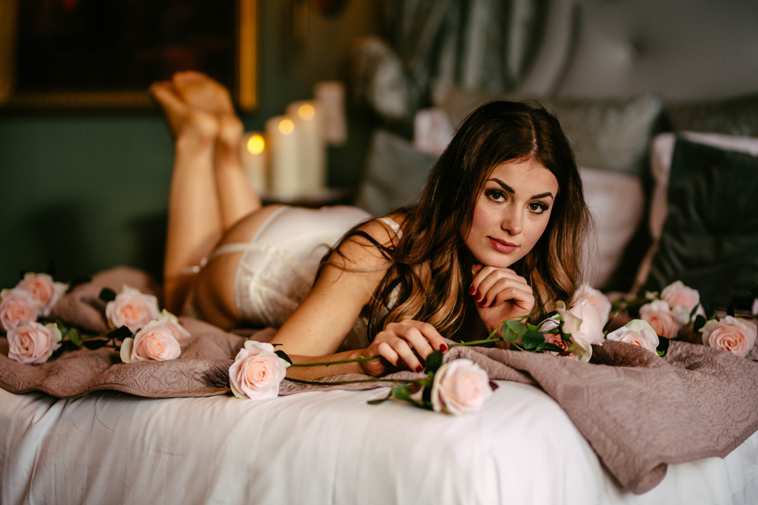 A boudoir shoot with a woman in lingerie surrounded by roses.