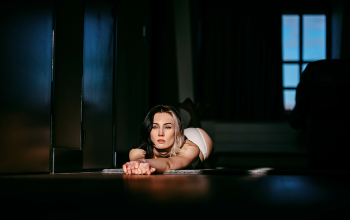 Een vrouw liggend op de grond voor een deur tijdens een boudoirshoot in het Westland.
