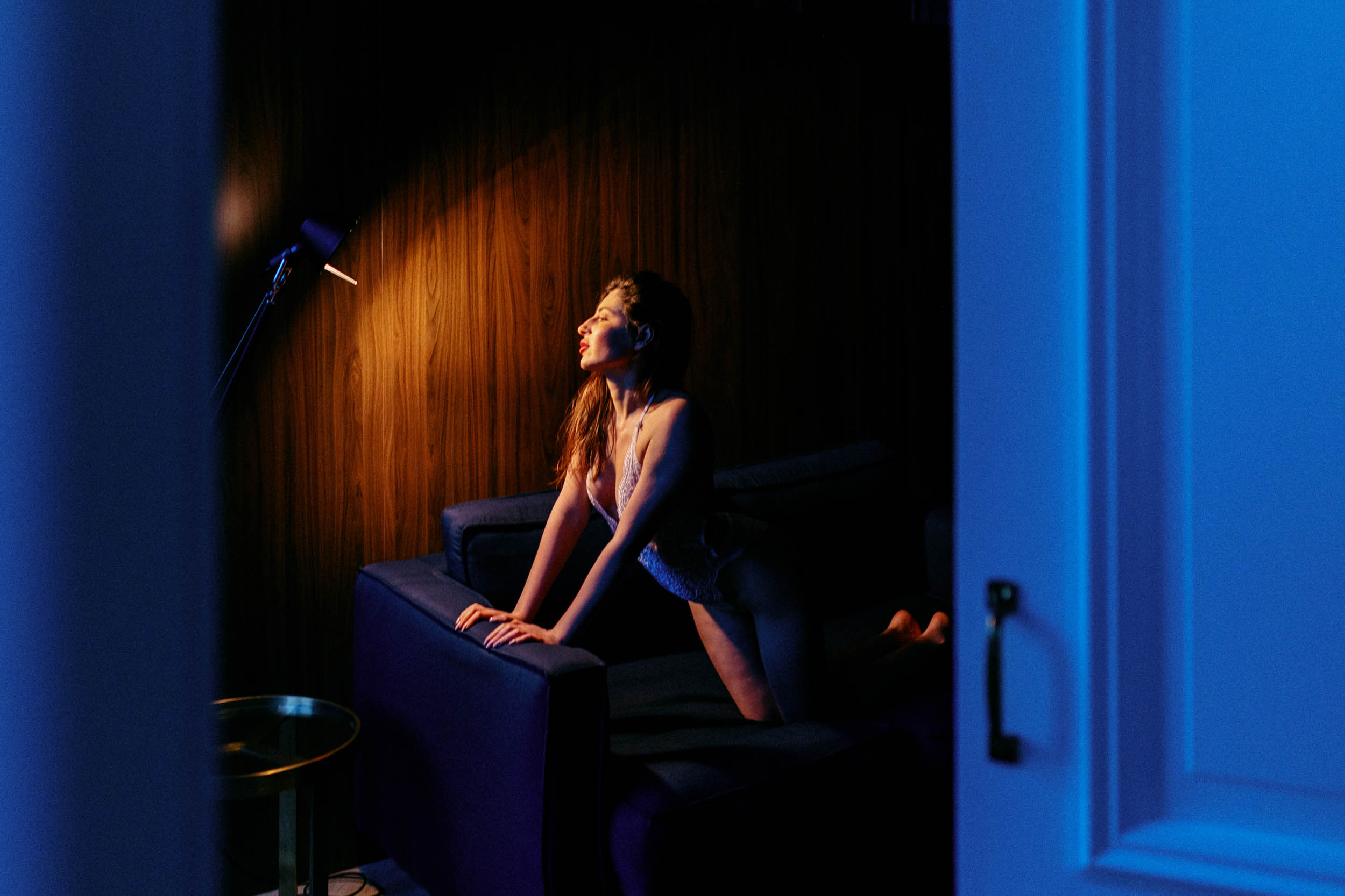 A woman poses on a sofa during a boudoir photo shoot in The Hague.