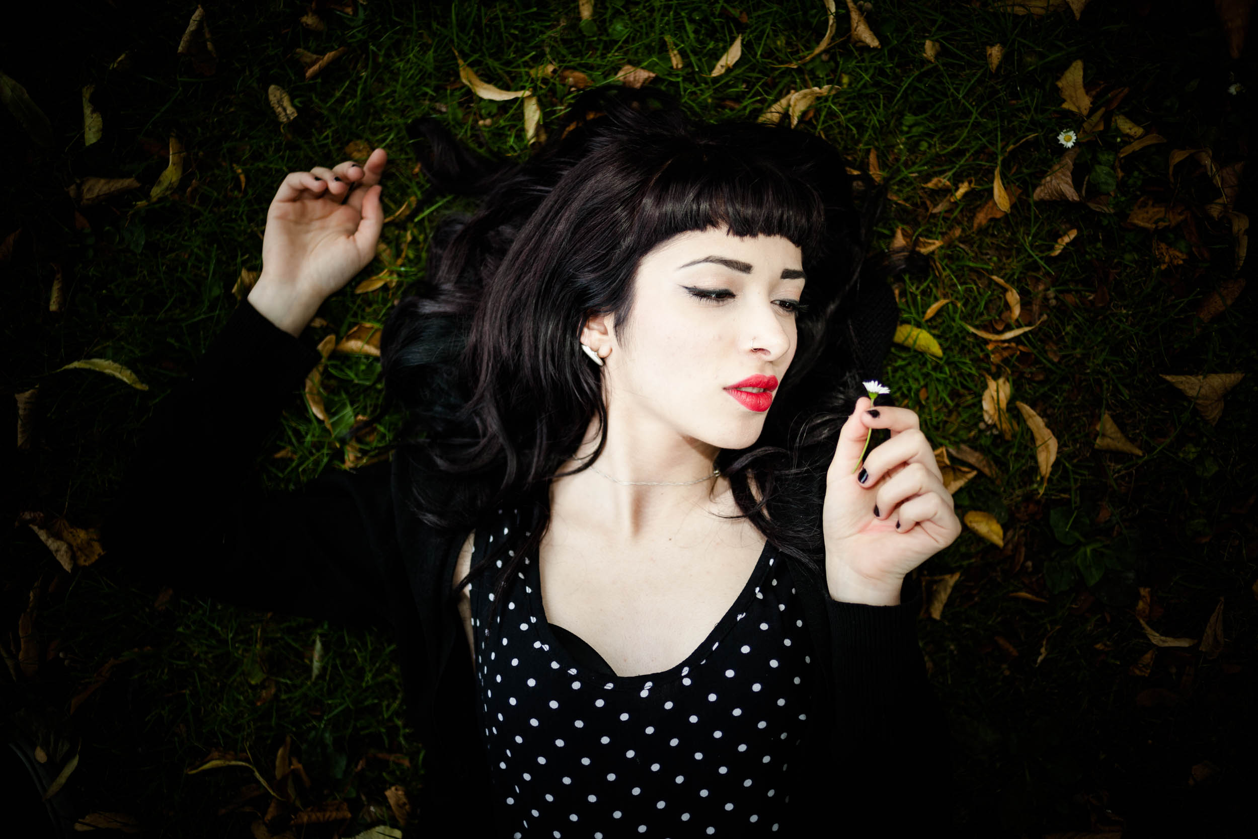 Een vrouw ligt op het gras en rookt een sigaret voor haar modelportfolio.