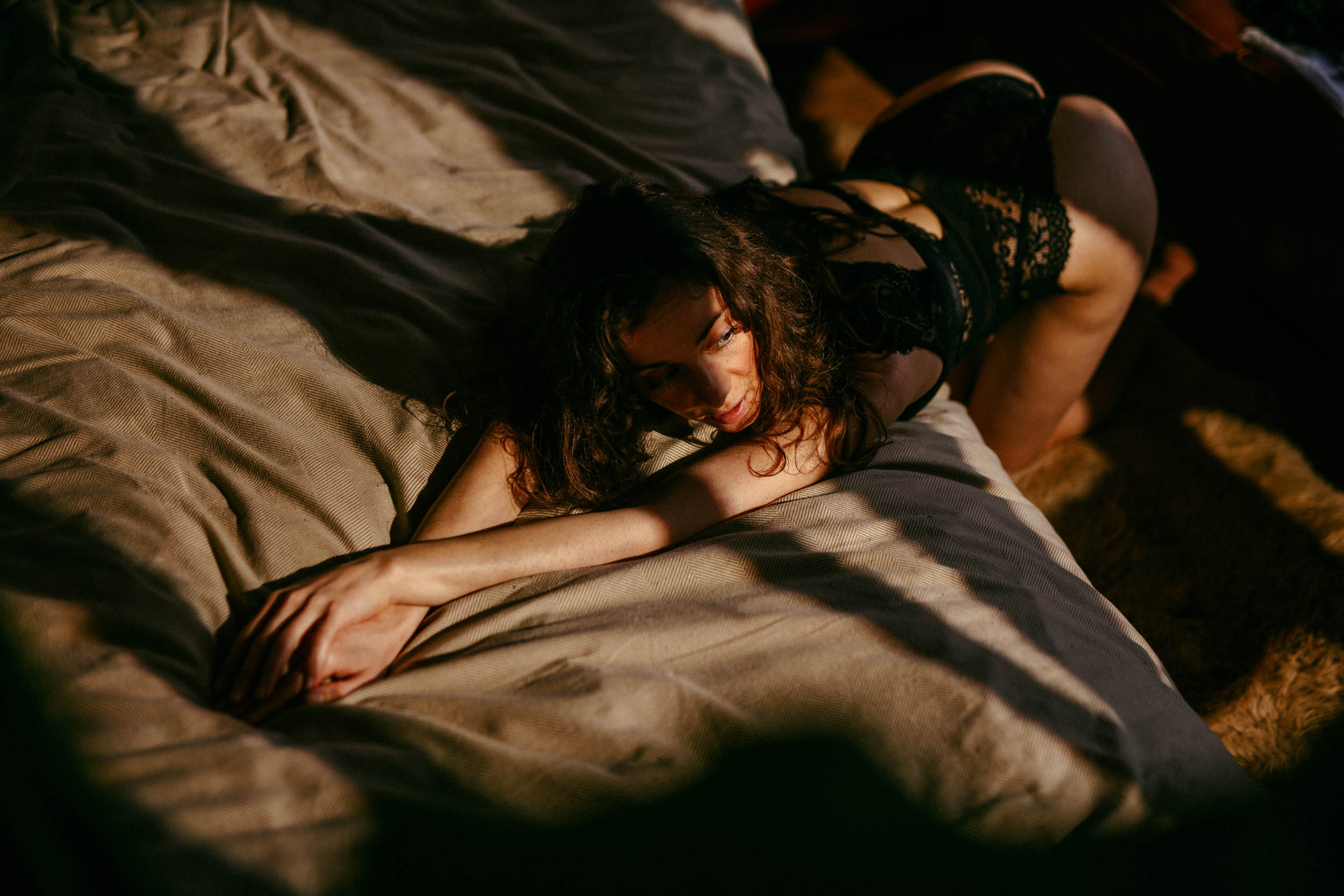 A woman lying on the bed in lingerie.